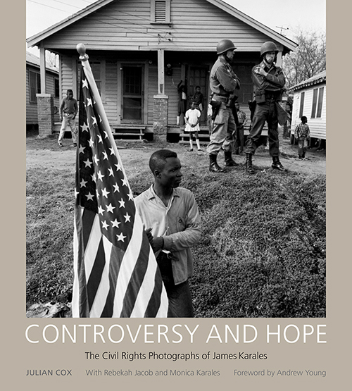 Cover of the book "Controversy and Hope" showing a photograph of a young African-American man carrying the American flag while white soldiers and African-American children look on. Photograph was taken during the 1965 Selma to Montgomery March for Voting Rights.