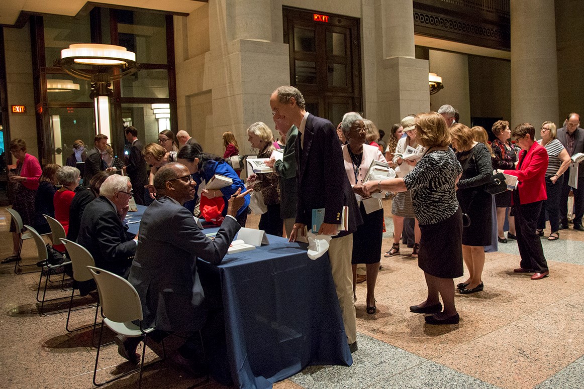 A man in a casual suit meets an Ohio author